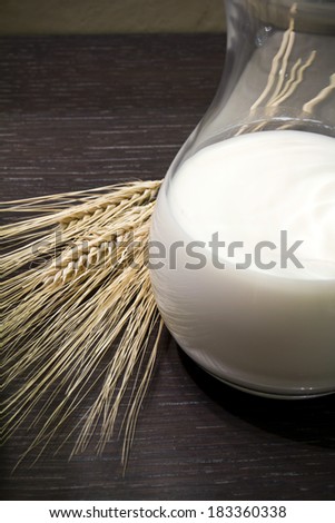 Milk in the pitcher, spaghetti, corn ears on wooden background
