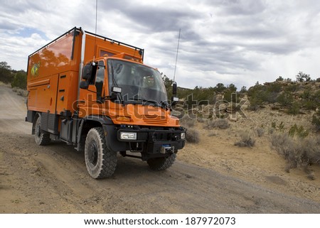 EL MORRO NATIONAL MONUMENT, NEW MEXICO, USA - April 18: Custom orange RV truck driving on dirt road on April 18, 2014 at El Morro National Monument, New Mexico, USA.