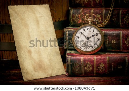 Vintage wood desk with old photo paper texture, books and old pocket clock in low-key. Concept of time,the past or deadline.