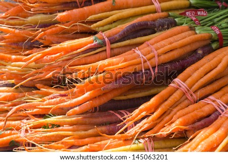 Fresh Carrots Bundled Together for Sale on Farmer\'s Market Table