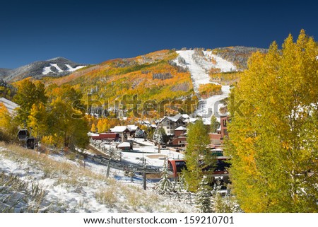 Snow on Golden Aspen Trees at Beaver Creek Resort, in Colorado with Ski Slopes and Gondola in Foreground