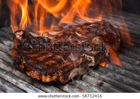 T-Bone Steak on Barbecue Grill Flames