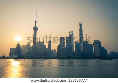 The sun rises over the skyscrapers of Shanghai.