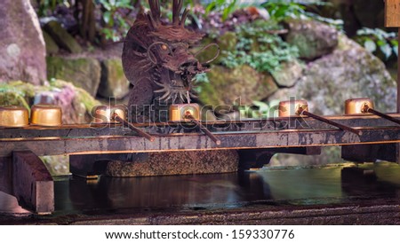 A row of ceremonial water cups at Hakone shrine in Japan.