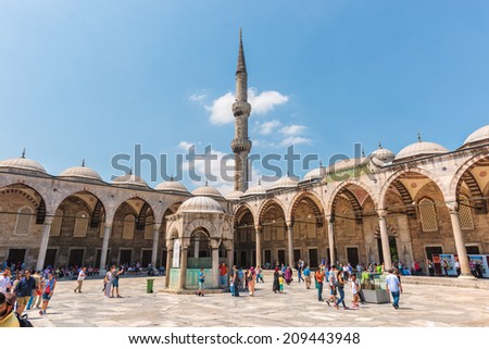 ISTANBUL, TURKEY - JULY 28: Muslims and tourists walk through the courtyard of the Blue Mosque, some to pray, others to marvel, on July 28, 2014 in Istanbul, Turkey.