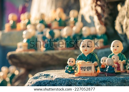 Little figurines scattered around the rocks of Haedong Yonggungsa Temple in Busan, South Korea. The figurines are meant to encourage academic achievement.