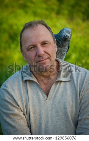 Portrait of  man with a gray parrot African grays Jaco.