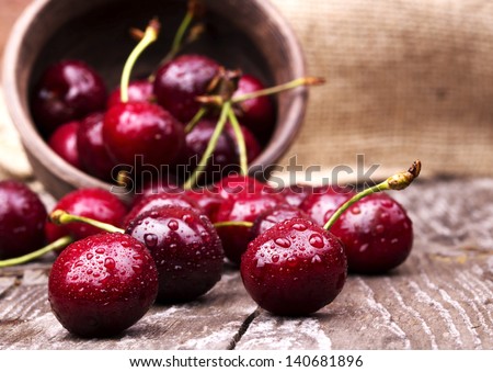 Similar – Image, Stock Photo Ripe cherries in wooden basket on grass. Container full of fruits