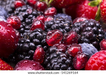 tasty summer fruits on a wooden table. Cherry, Blue berries,  strawberry, raspberries, Blackberries, pomegranate