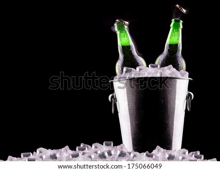 Beer bottles in ice bucket isolated on black