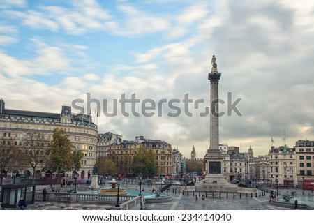 LONDON UNITED KINGDOM - NOVEMBER 18 , 2014: Tourists visit Trafalgar Square on a cloudy day. It's one of the most popular attraction in London, often considered the heart of London. November 18 , 2014