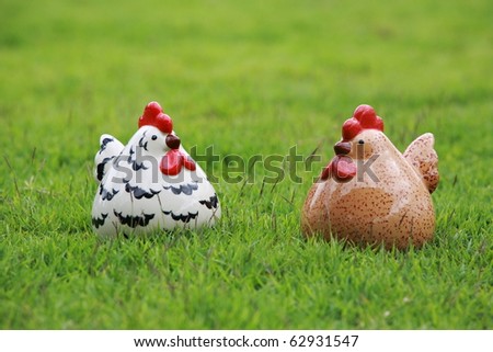 dual chickens statue on grass. made with baked clay.