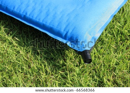 camping air mattress on grass.