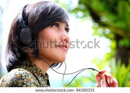 female listening music from ear pad headphone.