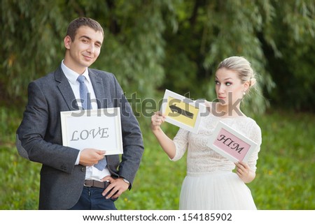 happy Groom and Bride in a park with signs