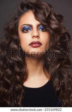 beautiful indian woman with curly hair in blue dress