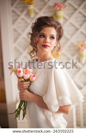 Fashionable attractive young woman in white dress in cafe in Provence style