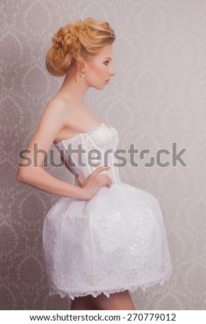 fashion bride in short dress with glamour makeup and hairstyle in luxury interior