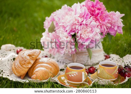romantic breakfast in nature with fresh croissants and tea on a summer day