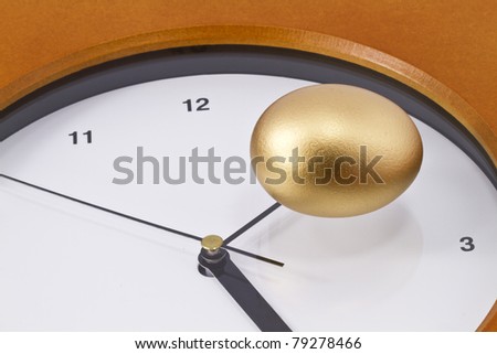 Gold nest eggs sits on ticking clock