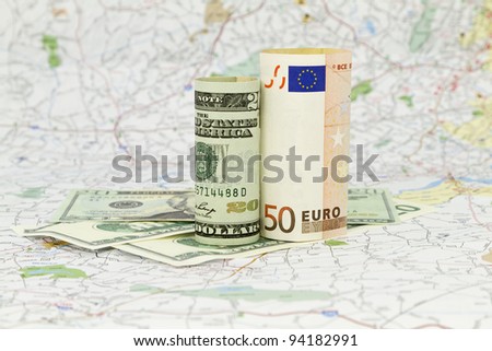 Two currencies, dollar and euro, placed on a map indicate the shared nature and dependencies within a global economy\'s market and financial system.