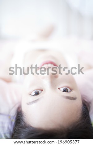 young beautiful woman lying in bed under blanket and dreaming