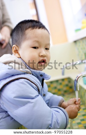 Chinese boy washing the hands beside the tank