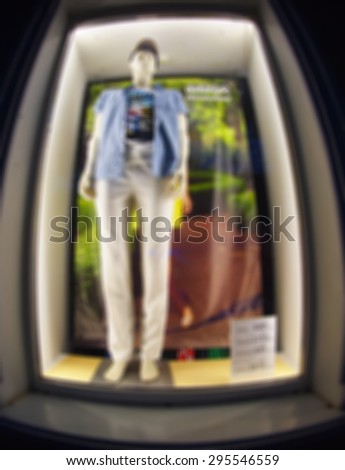 Defocused and blur bottom view of the male mannequin in the window, dressed in trousers, shirt and shirt was blurred for use as a background