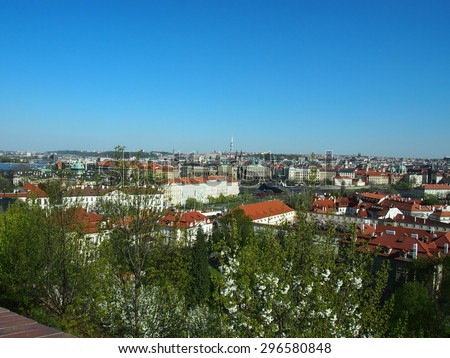 Prague, Czech Republic - April 21, 2015: Aerial view of the rooftops and the Prague Spring trees on the background of the clear blue sky