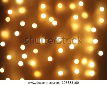 Defocused and blurry image of yellow round light bulb on the whole frame of the image. It can be used for background or wallpaper