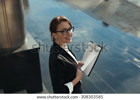 Young beautiful business woman thinking of her plans and smilling. Business lady manager doing business plan. Business people concept.