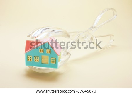 Kitchen Tongs with Toy House on Warm Background