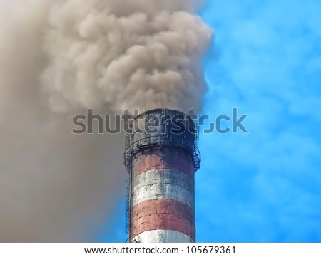Smoking chimney smelter against of the blue sky.