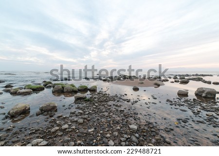 rocky sea beach with wide angle perspective over the sea clouds