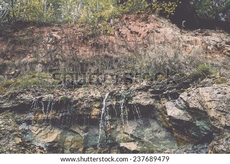 sandstone cliffs with water source. latvia. - retro, vintage style look