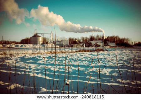 industrial park with chimney and white smoke on blue sky - retro vintage look