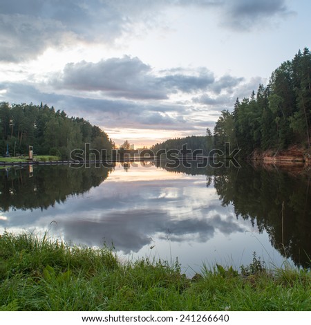 river with reflections in water and sandstone cliffs in latvia - square image