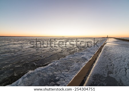 sunset over frozen sea with ice blocks and dramatic colorful sky