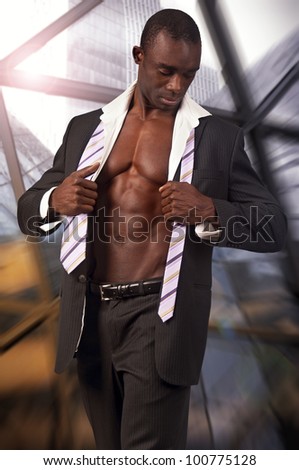 Young black man with muscular body and suit