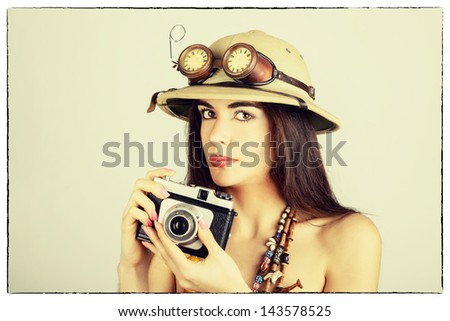 Vintage portrait of a girl with an explorer\'s hat and camera