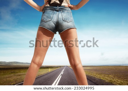 Woman\'s legs in the middle of an empty road in country side