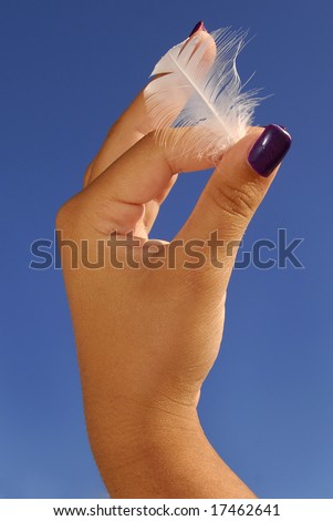 Woman\'s hand holding a feather