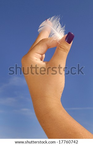 Hand holding a feather over a blue sky