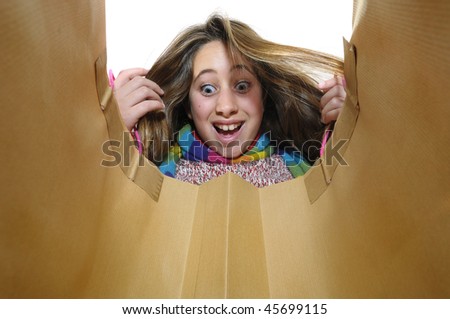 Beautiful young girl looking inside colorful bag isolated in white