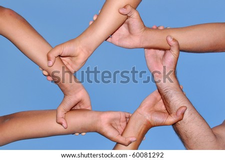 Human hands in a strong link against a deep blue sky