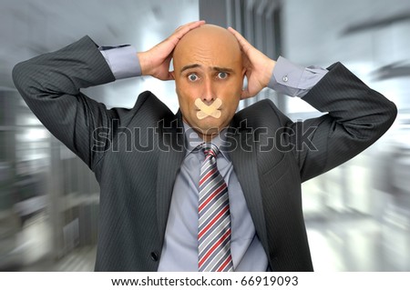 Distressed businessman with hands in his head and mouth covered with band aid