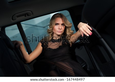 Beautiful blonde in the cabin of an expensive car