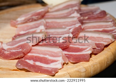 Pork belly cut into thin slices on a wooden board
