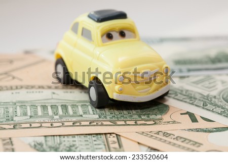 Toy car on a background of US dollars banknotes