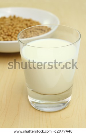 Soybeans and a glass of soy milk in foreground